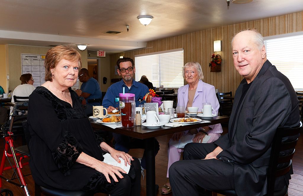 Residents and guests gathered around a dining table