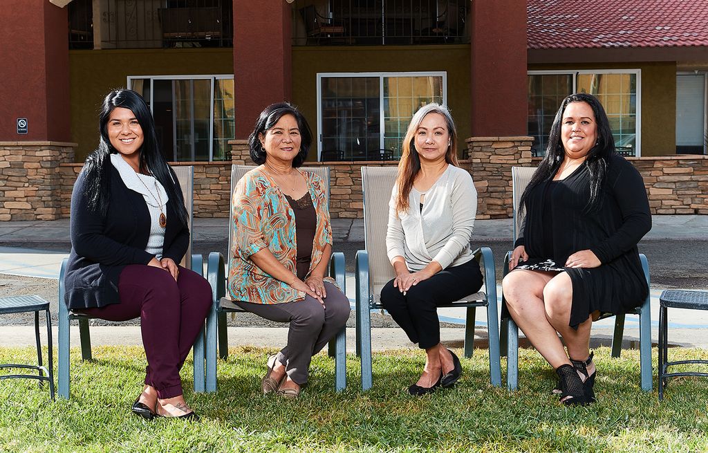 Four Vista Montana team members seated on the lawn