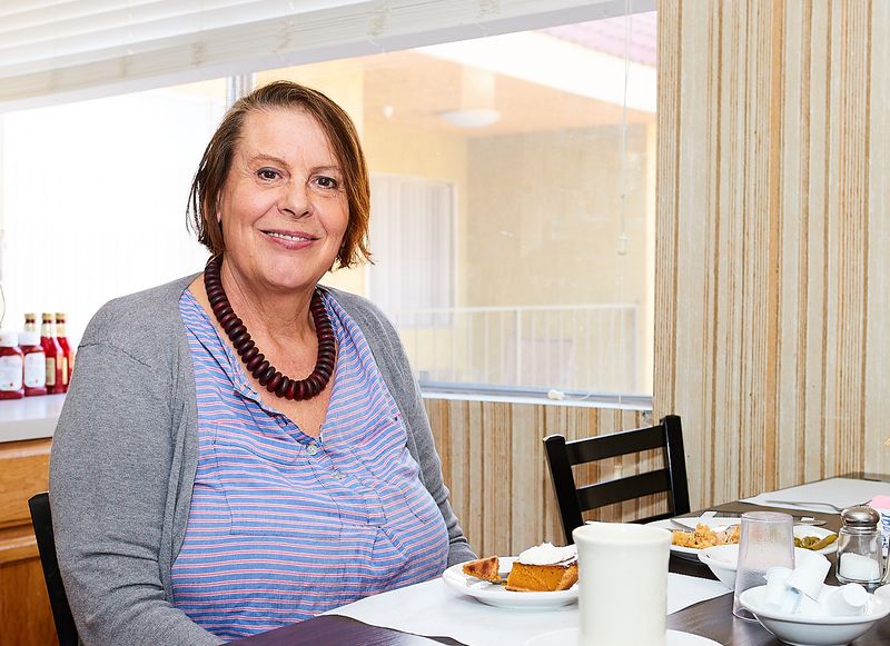 Smiling resident at a dining table