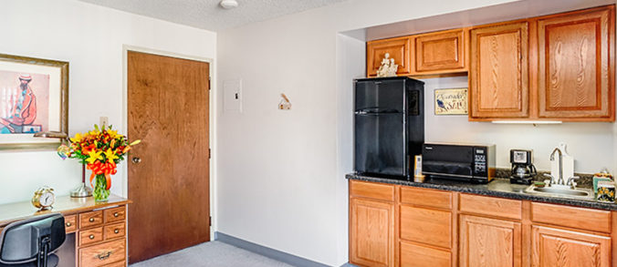 Apartment kitchenette with cabinets and appliances